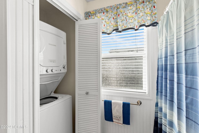 laundry area featuring stacked washer / drying machine