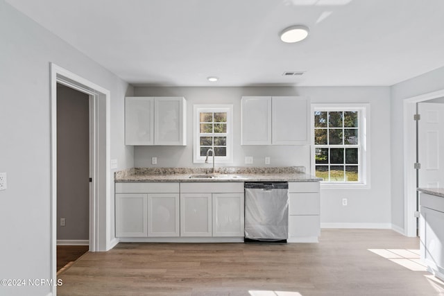 kitchen with dishwasher, a wealth of natural light, and white cabinets