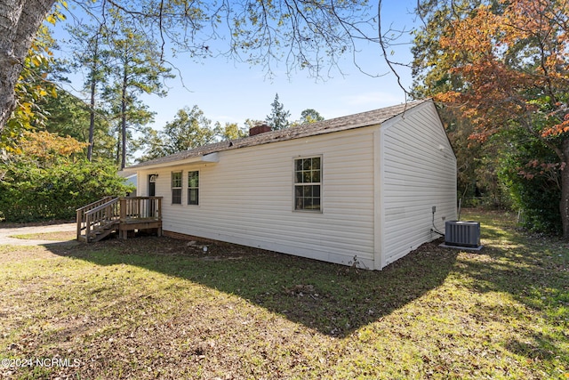 view of home's exterior with a wooden deck, a lawn, and central air condition unit