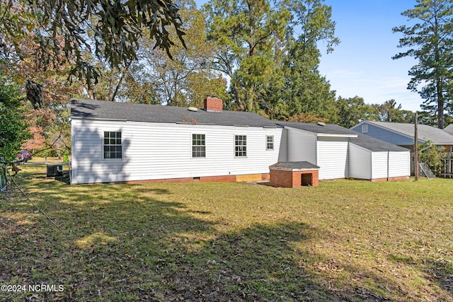 rear view of house with a yard and central AC