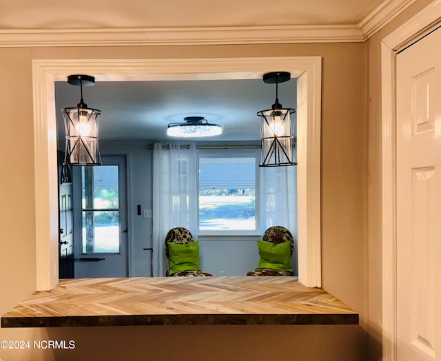 interior space with ornamental molding and decorative light fixtures