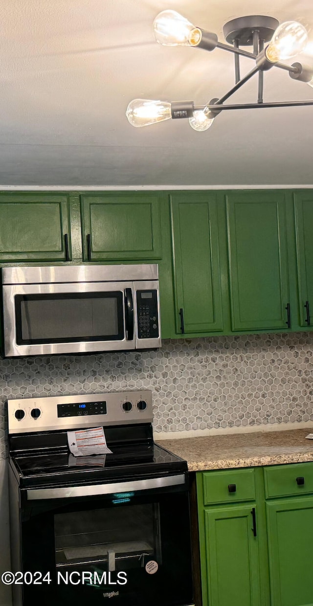 kitchen featuring backsplash, appliances with stainless steel finishes, and green cabinetry