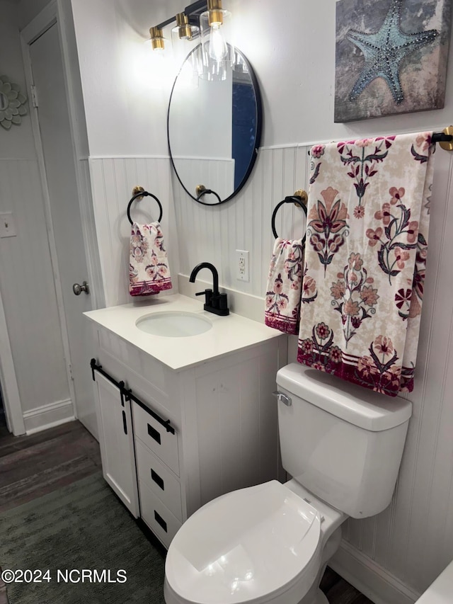 bathroom with vanity, toilet, and wood-type flooring