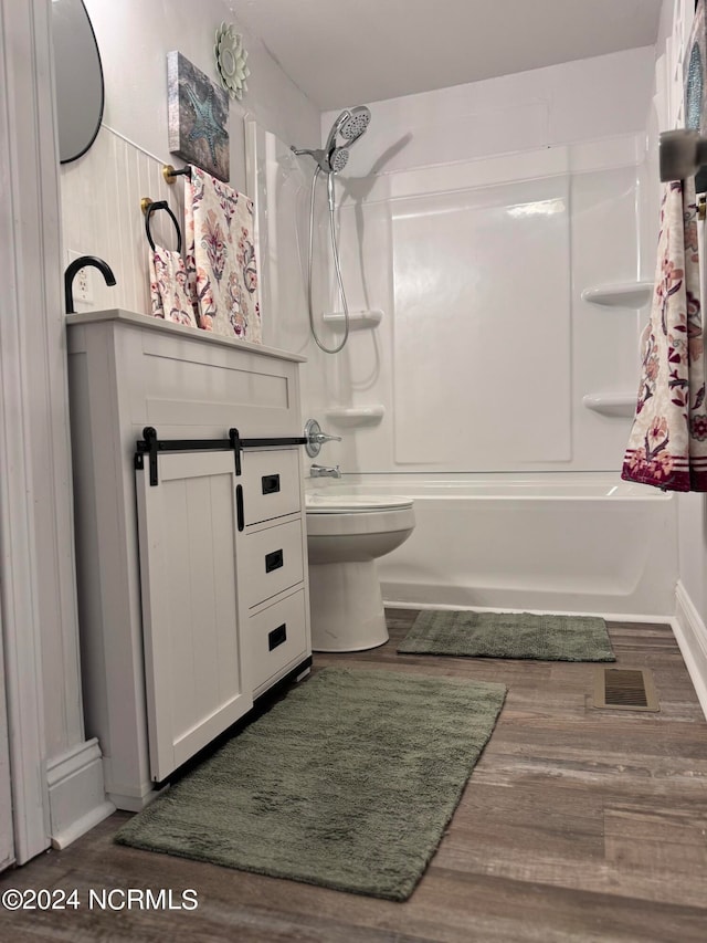 full bathroom featuring toilet, hardwood / wood-style flooring, vanity, and  shower combination