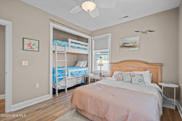 bedroom featuring a closet, visible vents, ceiling fan, wood finished floors, and baseboards