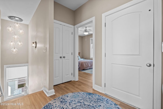 corridor with baseboards and wood finished floors