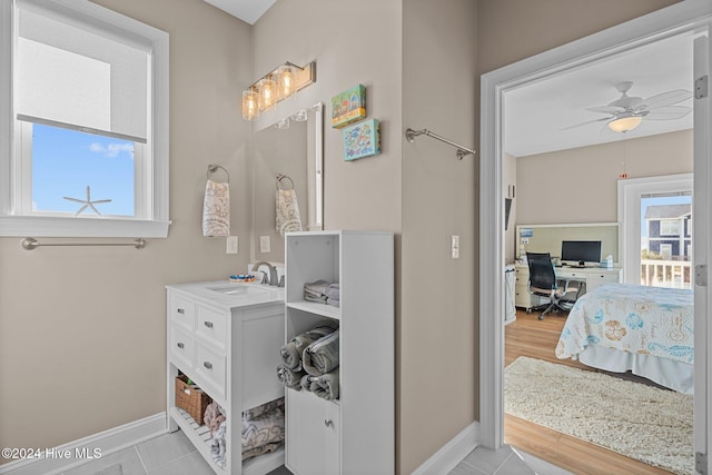 bathroom featuring baseboards, ensuite bath, ceiling fan, tile patterned flooring, and vanity