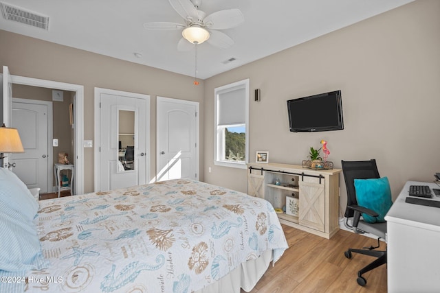 bedroom with light wood-type flooring, visible vents, and a ceiling fan