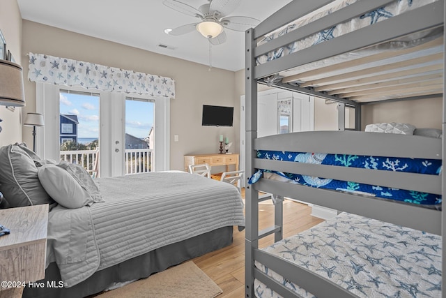 bedroom featuring access to exterior, a ceiling fan, visible vents, and wood finished floors