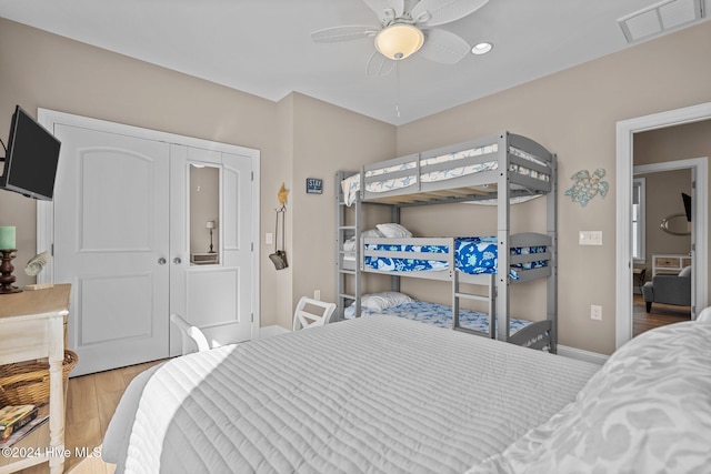 bedroom with baseboards, a ceiling fan, visible vents, and light wood-style floors