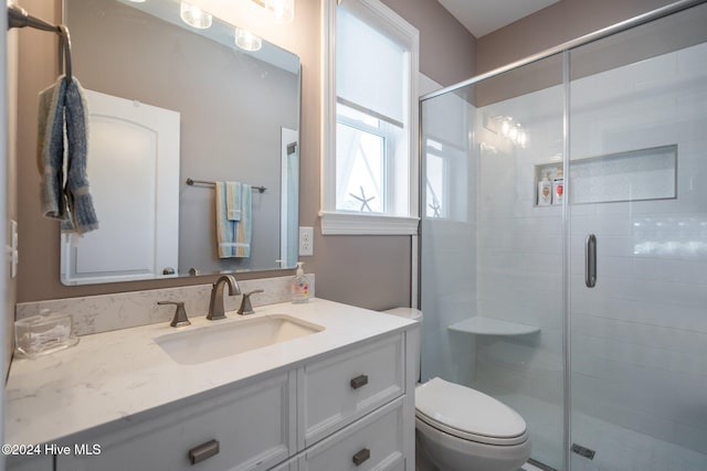 bathroom with toilet, a shower stall, and vanity