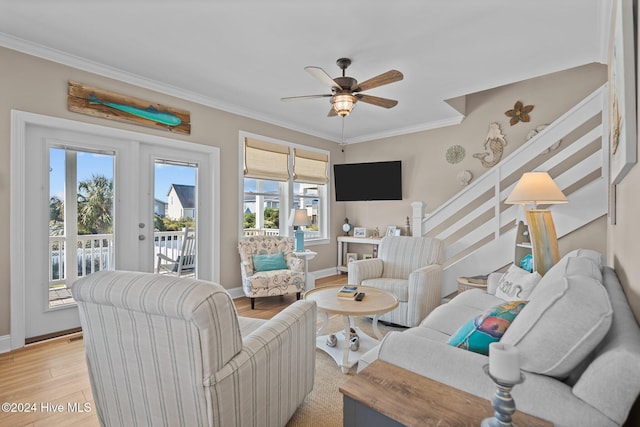 living room with baseboards, light wood finished floors, stairway, and crown molding