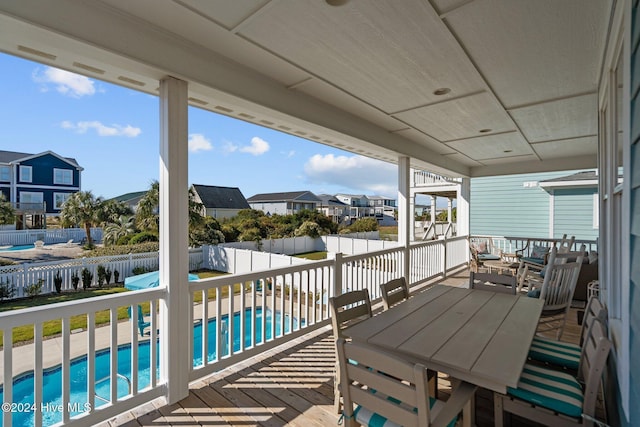 exterior space featuring a fenced backyard, a residential view, outdoor dining area, and a fenced in pool