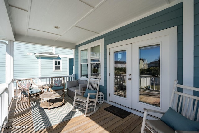 wooden deck with a porch and french doors