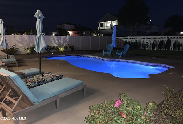 pool at twilight with a fenced in pool, a patio area, and a fenced backyard