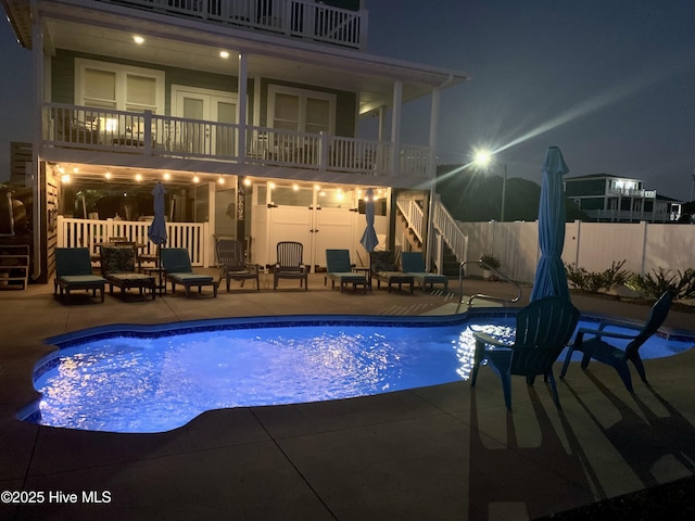 pool at twilight featuring stairs, a patio area, fence, and a fenced in pool