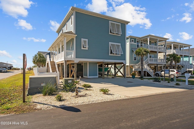 raised beach house with a carport and concrete driveway