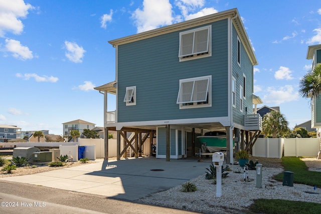 view of front facade with a carport, driveway, and fence