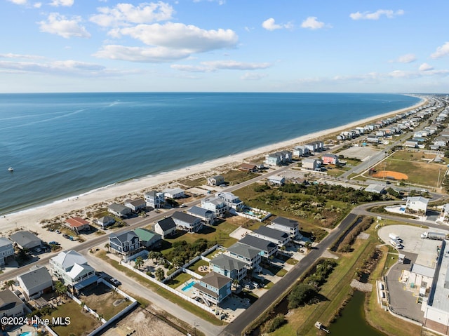 drone / aerial view featuring a beach view, a water view, and a residential view