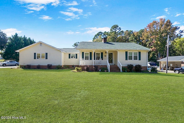 ranch-style house featuring covered porch and a front lawn