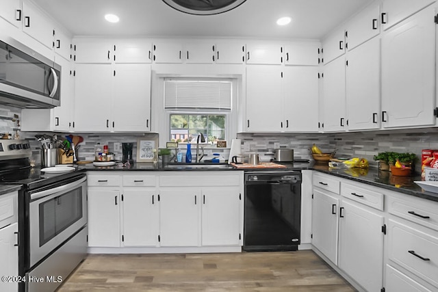 kitchen featuring decorative backsplash, hardwood / wood-style floors, white cabinetry, sink, and stainless steel appliances