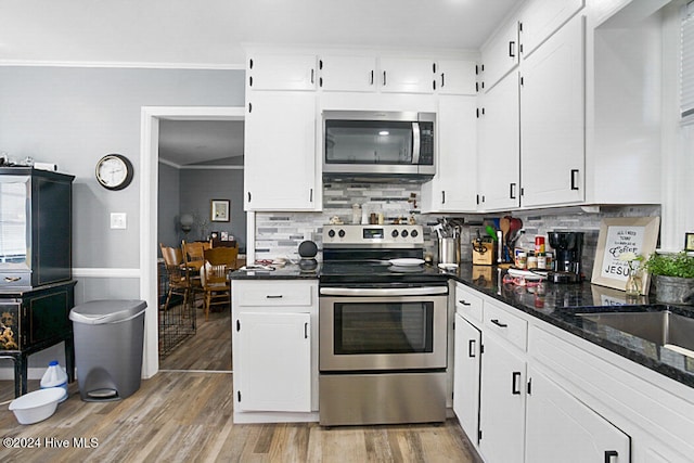 kitchen featuring crown molding, appliances with stainless steel finishes, and white cabinets