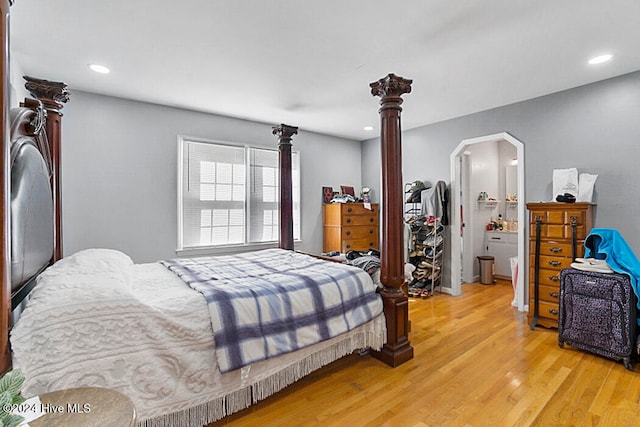 bedroom with light wood-type flooring and ensuite bath