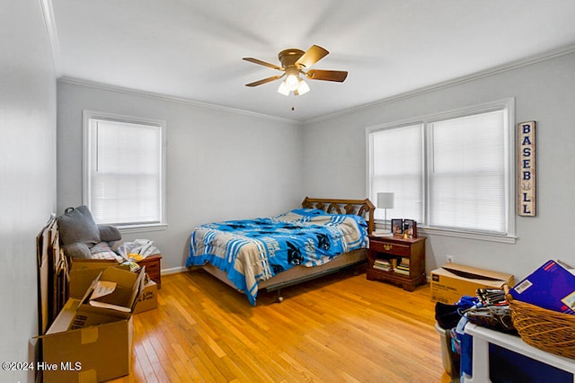 bedroom with multiple windows, ornamental molding, wood-type flooring, and ceiling fan