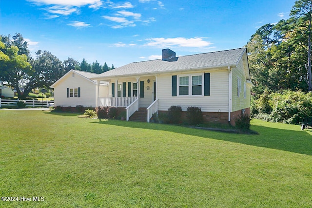 ranch-style home featuring covered porch and a front lawn