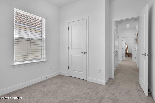 corridor with light carpet and a wealth of natural light