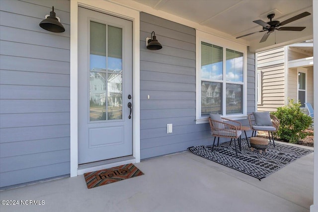 view of exterior entry with a porch and a ceiling fan