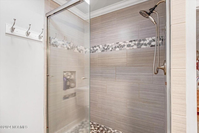 bathroom with ornamental molding and tiled shower