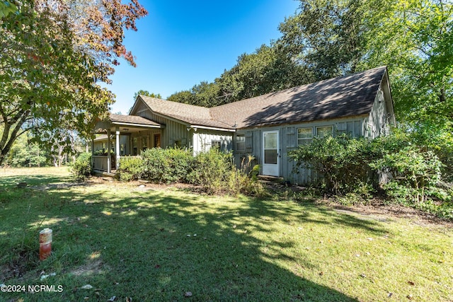 view of front facade featuring roof with shingles and a front yard