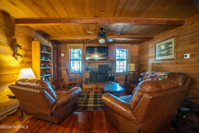 living room featuring wood walls, beam ceiling, wooden ceiling, hardwood / wood-style floors, and ceiling fan