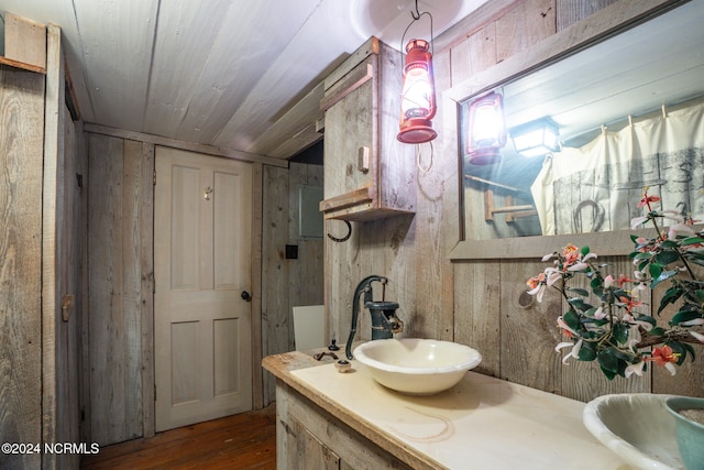 bathroom with vanity, hardwood / wood-style flooring, and wood walls