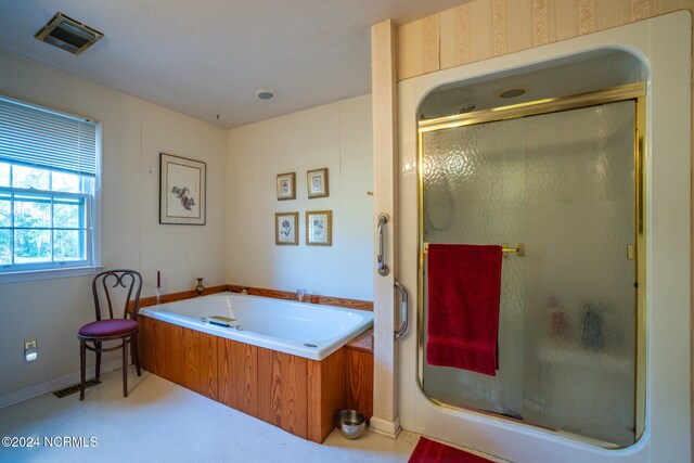 bathroom featuring separate shower and tub