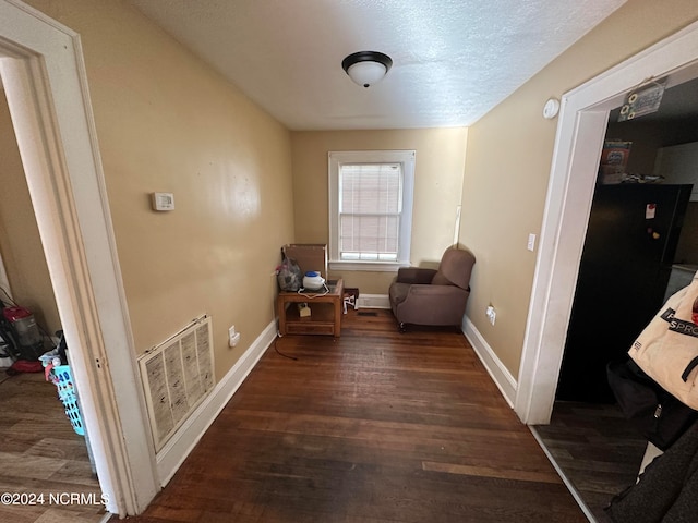 living area with a textured ceiling and dark hardwood / wood-style flooring