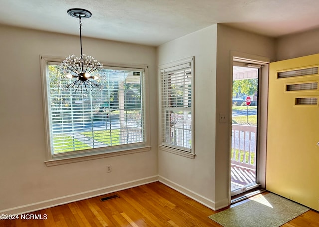 entryway with a notable chandelier and hardwood / wood-style flooring