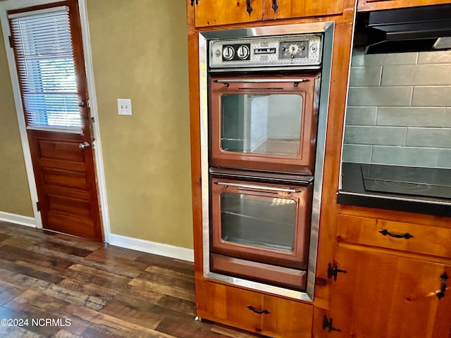 kitchen featuring black double oven and dark hardwood / wood-style flooring