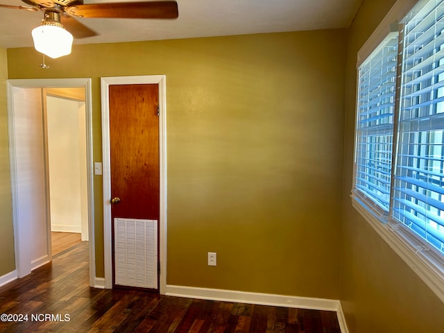 spare room with dark wood-type flooring and ceiling fan