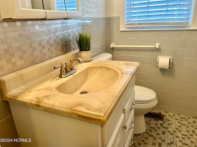 bathroom with vanity, a healthy amount of sunlight, and toilet