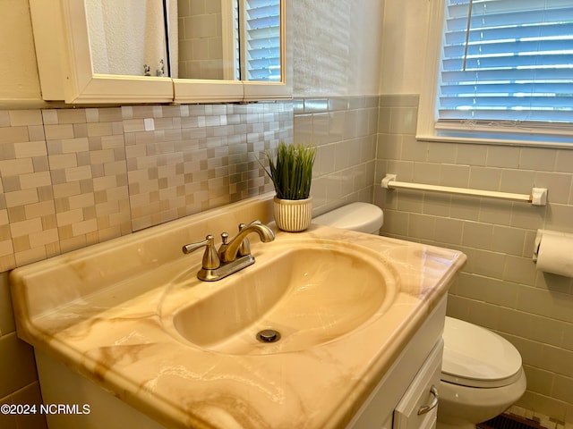 bathroom with a wealth of natural light, vanity, and toilet