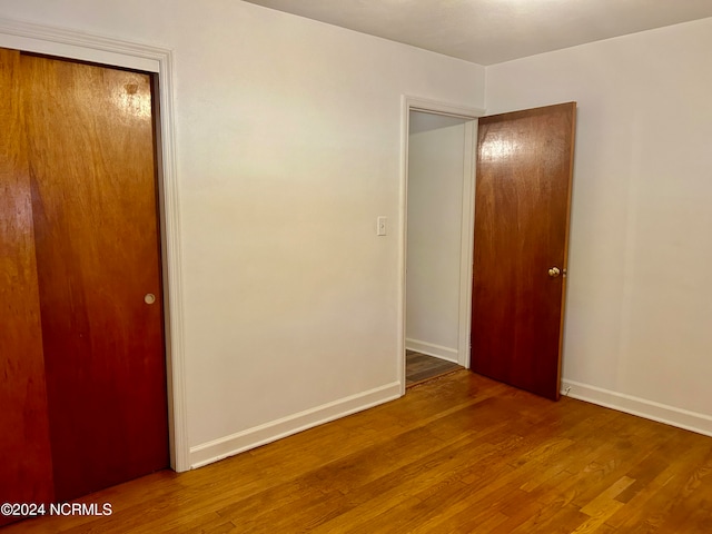 unfurnished bedroom with hardwood / wood-style floors and a closet