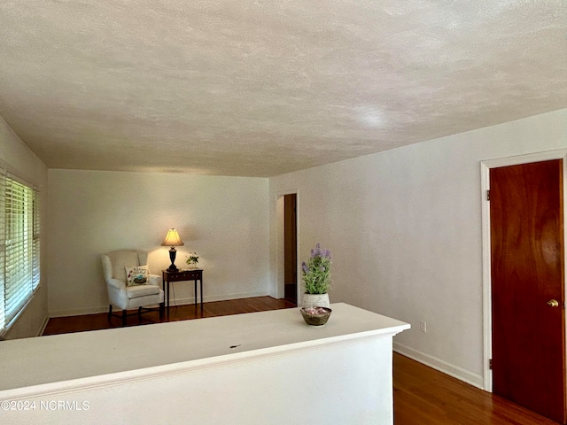 interior space with a textured ceiling and dark hardwood / wood-style flooring