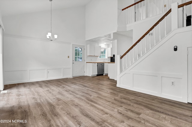 entrance foyer featuring a notable chandelier, high vaulted ceiling, and light wood-type flooring