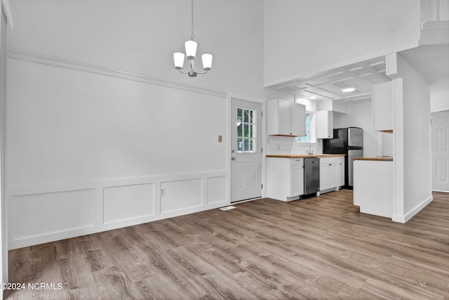 kitchen with wooden counters, dishwasher, hanging light fixtures, white cabinets, and light hardwood / wood-style floors