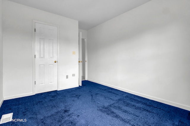 unfurnished bedroom with dark carpet