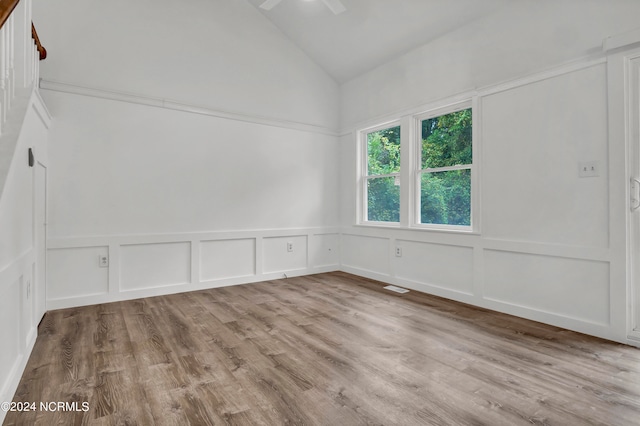 empty room with vaulted ceiling and light wood-type flooring