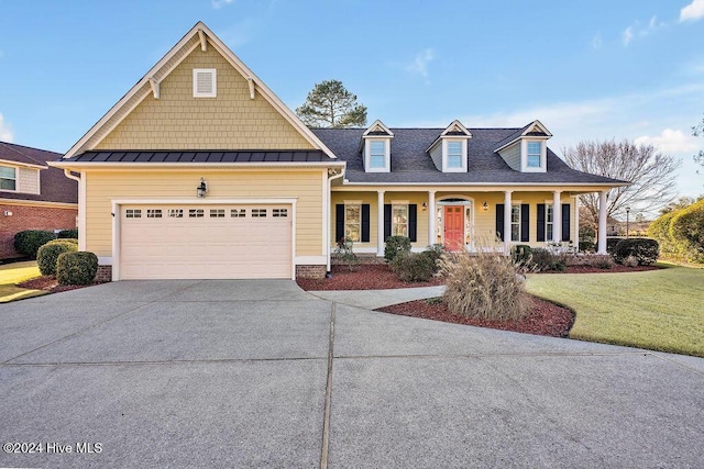 view of front of house featuring a garage, a porch, and a front yard