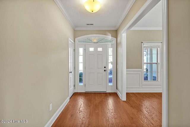 entryway with hardwood / wood-style floors and crown molding